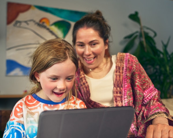 Mamma och barn läser bok på tablet