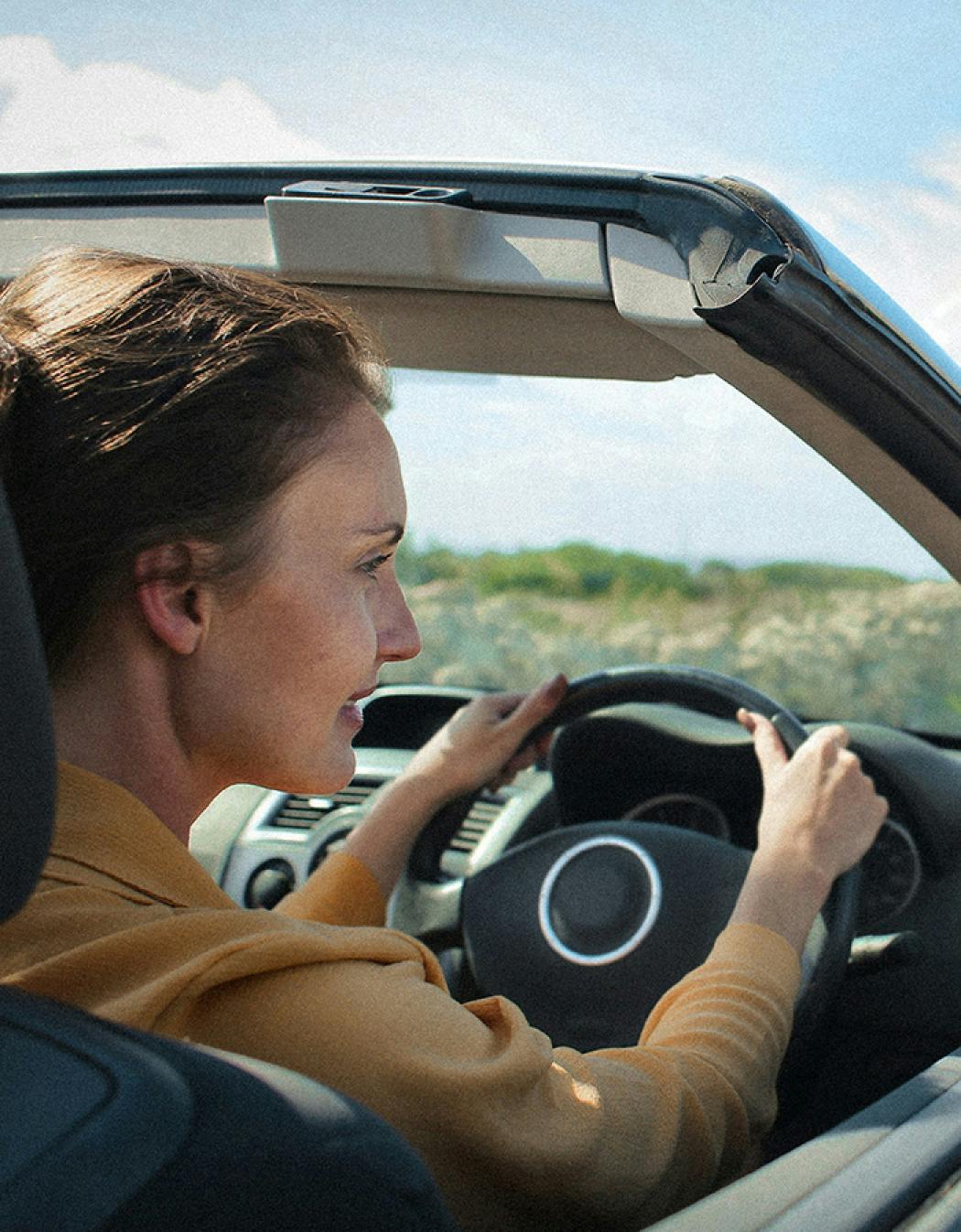 Lächelnde Frau während einer Autofahrt.